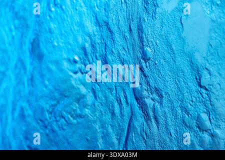 Blue textured background showing an abstract pattern of rough uneven surfaces and grooves. Useful as a backdrop Stock Photo