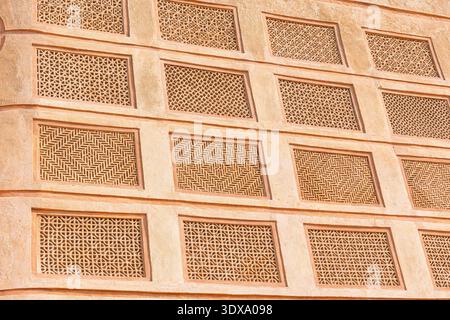Traditional intricate patterns decorating an old stone wall, showcasing ancient craftsmanship and architectural detail Stock Photo