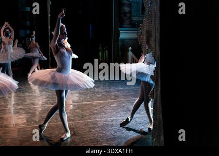 Classical ballet dancer in white tutu performing on stage Stock Photo