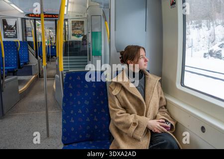 Solo Female Traveler Sitting in Train Looking Through Window.  Stock Photo