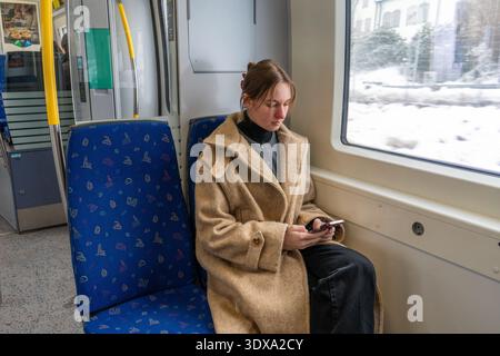 Young Woman Working Remotely on Train During Winter Travel.  Stock Photo