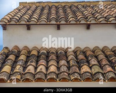 Traditional terracotta roof with curved, clay tiles arranged in a uniform pattern, often used in Mediterranean and Spanish-style architecture, have a Stock Photo