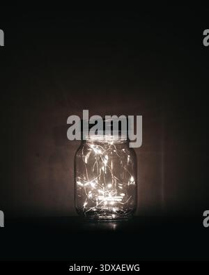 Glass Jar with Fairy Lights Glowing in the Dark Stock Photo