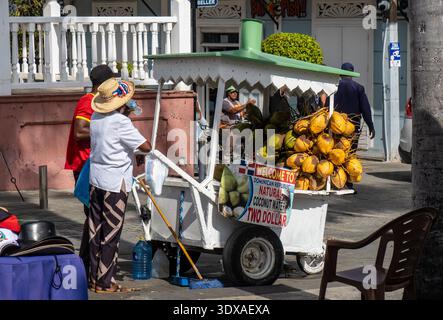 Man selling coconut water from his cart on the street in Puerto Plata Dominican Republic. Stock Photo