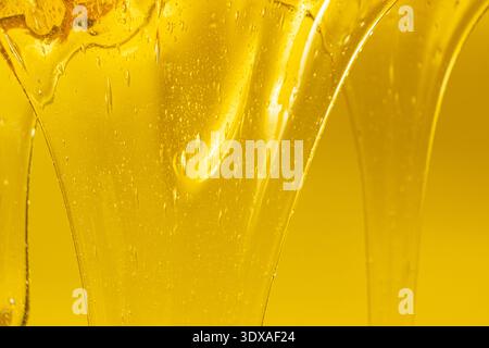 Flowing golden honey with air bubbles texture. Stock Photo