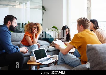 Business professionals planning strategies while sitting in modern office Stock Photo
