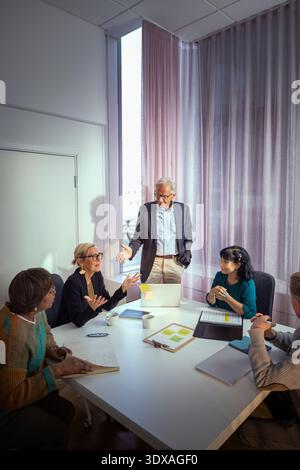 Group of senior entrepreneurs discussing in office team meeting Stock Photo