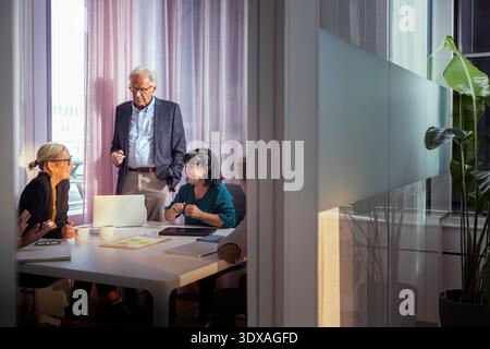 Smiling male and female business professionals discussing strategies Stock Photo
