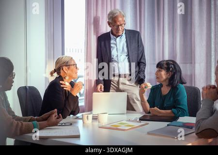 Group of senior entrepreneurs sharing business ideas in meeting room Stock Photo