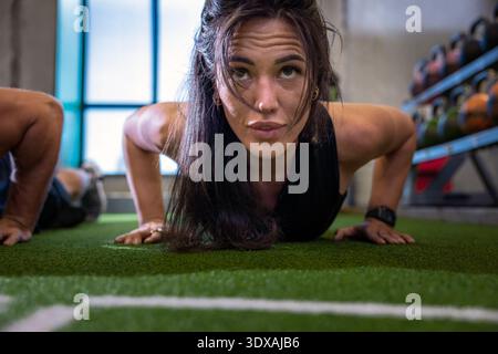 Woman doing push ups in gym Stock Photo