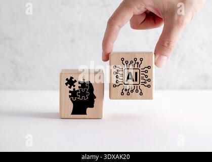 Hand placing a wooden block with artificial intelligence chip symbol next to a human head outline with puzzle pieces. Human and ai interaction, creati Stock Photo