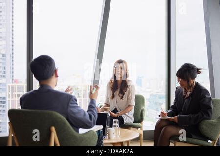 Male manager explaining business ideas to female employees in meeting at office Stock Photo