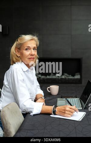 Portrait of senior female entrepreneur at desk in office Stock Photo