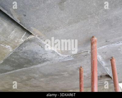 View of a concrete ceiling with support pillars in an industrial setting. The image captures construction details. Stock Photo