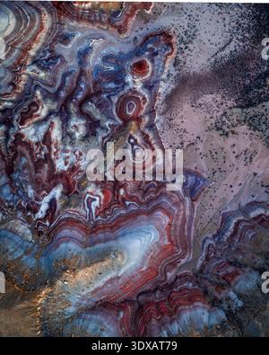 Aerial view of swirling patterns of red, white, blue and grey earth tones creating an otherworldly landscape, Hanksville, Utah, United States. Stock Photo