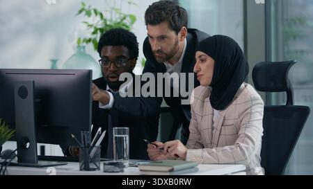 Multicultural business colleagues teamwork in office multiracial three co-workers working together diversity partners businesspeople talking pointing Stock Photo