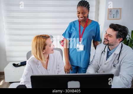 Medical professionals collaborating on computer in clinic office Stock Photo