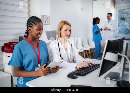 Medical professionals collaborating on computer in clinic office Stock Photo
