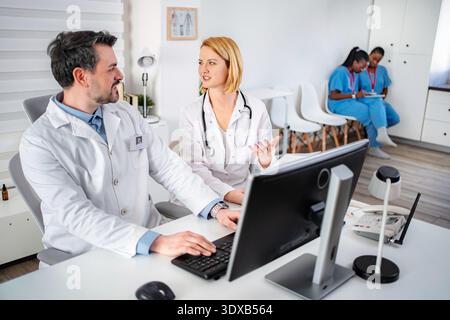 Medical team collaborating in busy clinic office Stock Photo
