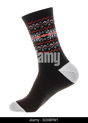 Black crew sock with red and gray snowflake pattern on foot mannequin isolated on a white background Stock Photo