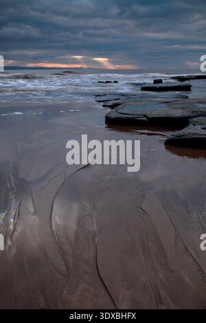 Sun rays breaking through storm clouds over the Bristol Channel at Dunraven Bay, Glamorgan Heritage Coast, South Wales, United Kingdom. Stock Photo