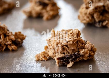 Mounds of raw oatmeal raisin cookie dough placed on a greased metal baking sheet, ready for the oven in a home kitchen in Waukesha County, Wisconsin. Stock Photo