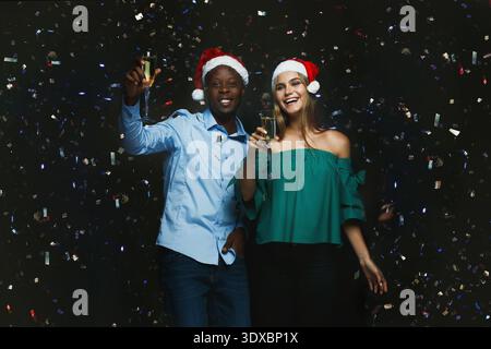 Holiday Celebration With Friends Enjoying Drinks and Confetti in a Festive Setting Stock Photo