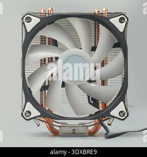cpu cooling fan mounted on tower cooler isolated grey background, plastic blades and metallic heatsink fins, side view Stock Photo