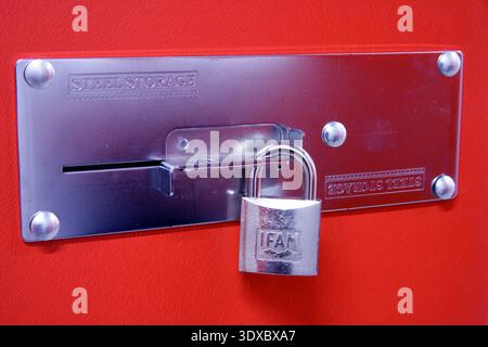 Silver Padlock Securing Steel Storage Plate On Red Locker Door Representing Security And Protection Stock Photo