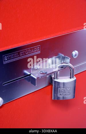 Silver Padlock Securing Steel Storage Plate On Red Locker Door Representing Security And Protection Stock Photo