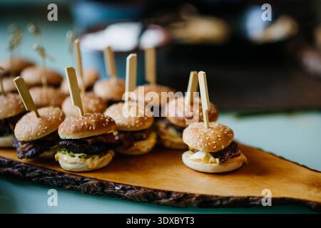 Mini burgers served on buffet table at party catering event. Mini burgers served on buffet table at party catering event. No people. model released Stock Photo