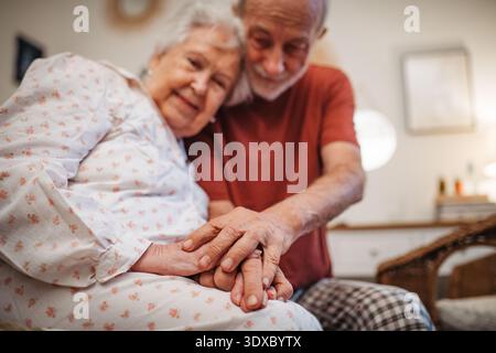 Elderly spouses sharing quiet moment before sleep. Stock Photo