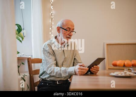 Elderly man using tablet, shopping online. Stock Photo