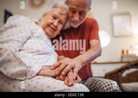 Elderly spouses sharing quiet moment before sleep. Elderly spouses sharing quiet moment before sleep. Bedtime concept. model released Stock Photo