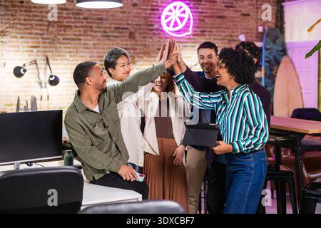 Startup team celebrating success, giving high five in modern office Stock Photo