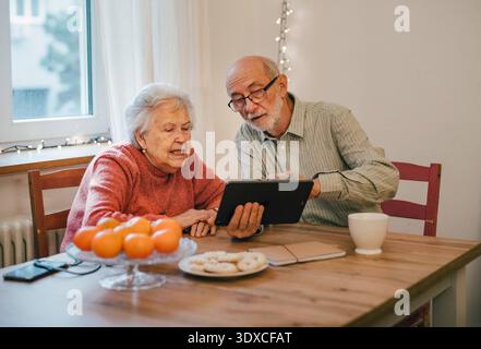 Senior coule working with tablet, having problem with technology. Senior coule working with tablet, having problem with technology. Digital literacy. Stock Photo
