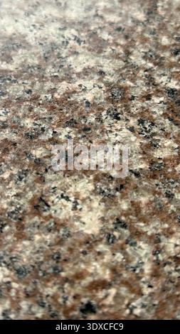 Granite texture with a mix of brown, black, and white speckles, suitable for background use. Mobile photo Stock Photo
