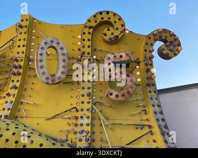 Close-up of weathered vintage marquee sign with rusted bulbs and yellow metal background. Stock Photo