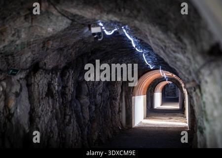 A perspective view inside a military gallery carved into the limestone rock of Mount San Michele. The photo highlights the contrast between the raw ro Stock Photo