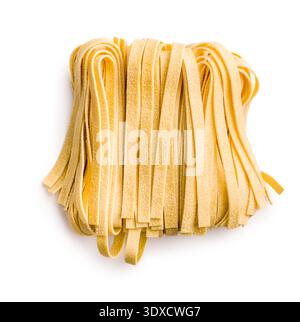Strands of fettuccine pasta rest on a white surface, appearing soft and fresh. This type of pasta is often used in various dishes. Stock Photo
