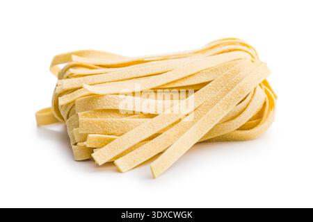 Strands of fettuccine pasta rest on a white surface, appearing soft and fresh. This type of pasta is often used in various dishes. Stock Photo