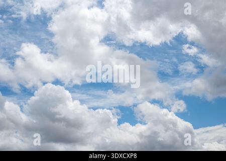 Dramatic white clouds against a deep blue sky in summer. nature background, weather forecast, clear sky. Stock Photo