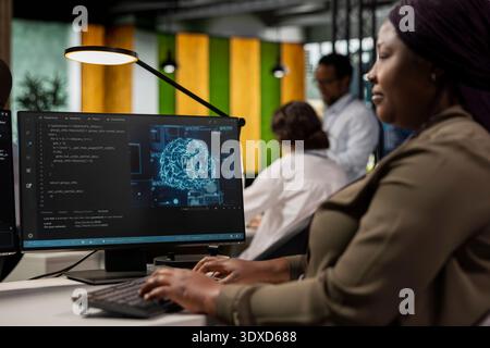 System administrator in AI tech company workplace using PC to conduct code reviews. IT specialist using computer program at office desk to design and implement machine learning algorithms Stock Photo