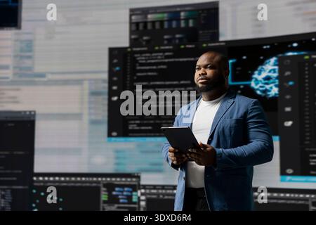 Black engineer explores algorithm design and binary code with high tech AI tools, programming code for automation and innovation. Connection to IT systems and the futuristic world. Stock Photo