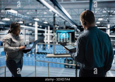 Data center expert assisting users with AI enhanced troubleshooting, delivering technical support. Server room technician talking in headset mic with users in need of assistance Stock Photo