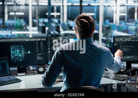 Engineer in data center using AI LLM assistant to perform maintenance on infrastructure rigs. Server room worker using large language model chatbot to do backup on storage arrays Stock Photo