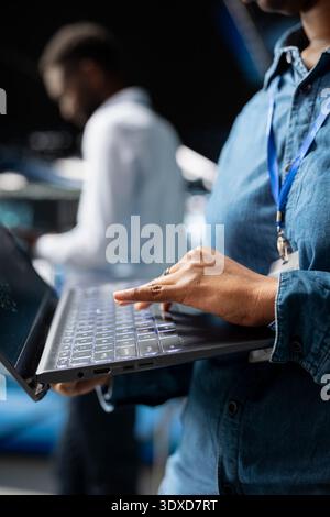 Close up of female supervisor overseeing staff doing AI automatization, machine learning for servers infrastructure. Data center specialist managing operations with artificial intelligence. Stock Photo