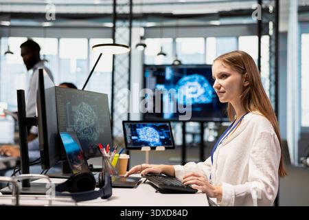 Young tech startup admin in office integrating AI machine learning systems to streamline workflows. Female programmer uses neural networks artificial intelligence, technology overload concept Stock Photo