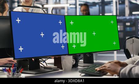 Data center engineer using green screen PC to monitor neural network AI. Server room employee using chroma key computer to oversee rigs powering machine learning processes, camera A Stock Photo