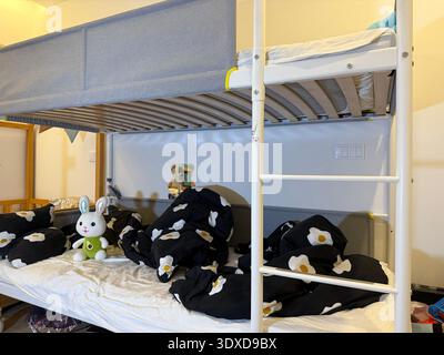 stuffed rabbit on bunk bed, egg bedding, cozy kids room, unmade bed, concept of decor, interior. Stock Photo